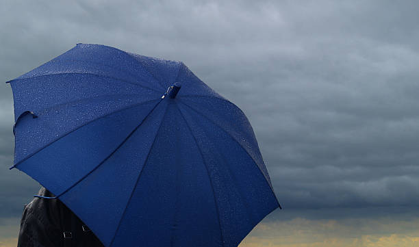 istock Blue umbrella over a dark stormy cloud 92008414
