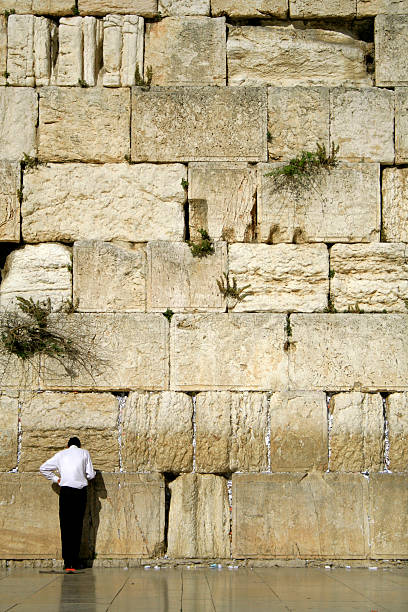 istock man praying next to the wailing wall 92009839