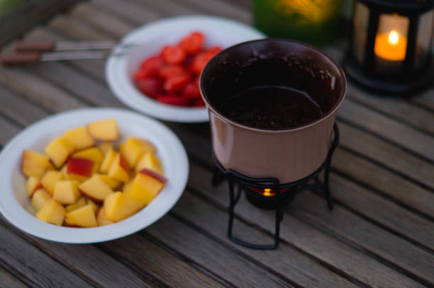 Romantic dinner with chocolate fondue and pieces of fruits