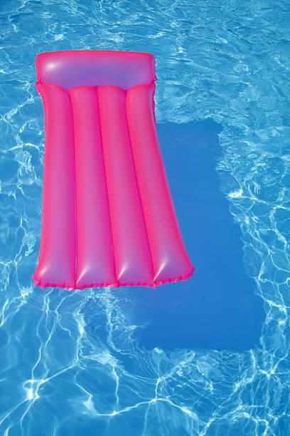 istock Pink air bed floating on a swimming pool 92010970