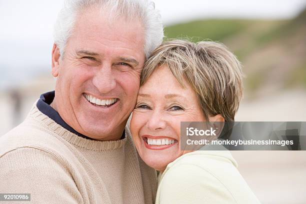 Sonriente Pareja En La Playa Foto de stock y más banco de imágenes de Tercera edad - Tercera edad, Pareja mayor, Playa