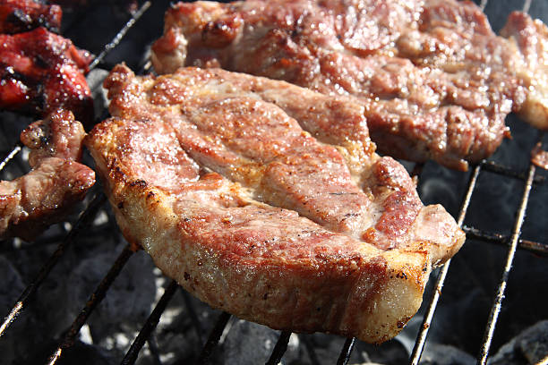 istock meat bbq thick seasoned pork chops cooking on the grill 92011048