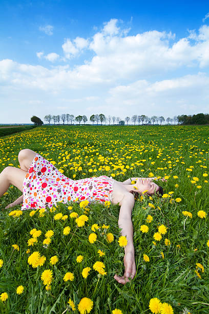 istock beautiful young woman relaxing between dandelions 92011525
