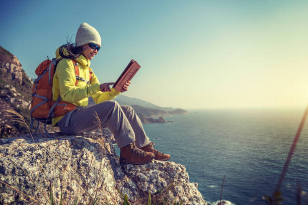 istock Young Woman Hiker Using digital tablet while hiking at Seaside 920121394