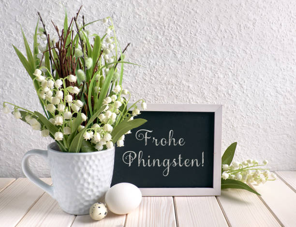 Blackboard decorated with lily of the valley flowers and eggs, text Easter composition with blackboard decorated with ceramic hen, eggs and and lily of the valley flowers. Caption "Frohe Phingsten" means "Happy Pentecost" in German. pentecost religious celebration photos stock pictures, royalty-free photos & images