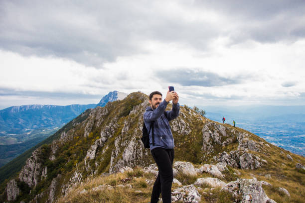 istock Young man on top of the mountain making selfie. 920128808