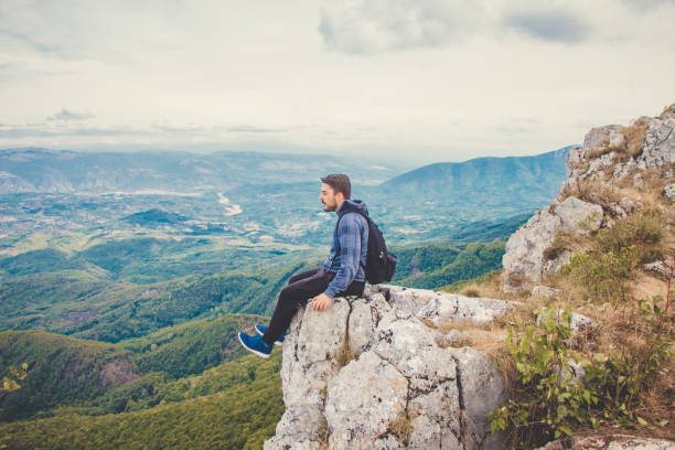 istock Young man on on high cliff. Mountain view. 920128864