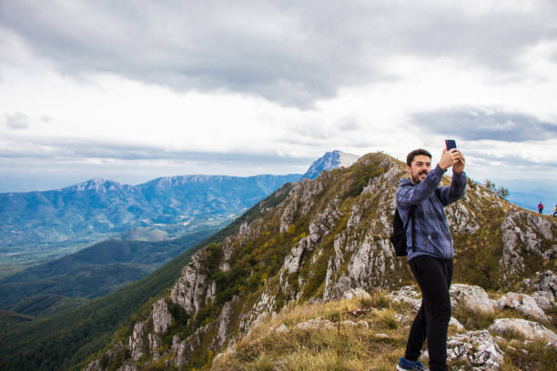 istock Young man on top of the mountain making selfie. 920128914