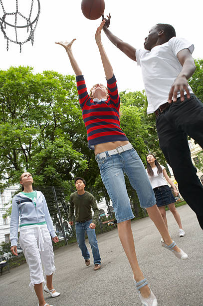 A girl and man playing basketball with each other Friends playing streetball schoolyard fight stock pictures, royalty-free photos & images