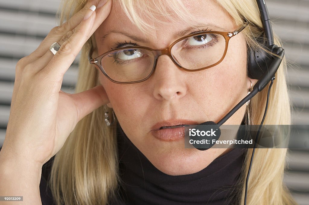 Businesswoman with Phone Headset and Headache  Hotel Reception Stock Photo