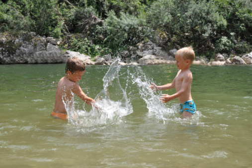 Two little boys enjoying a carefree summer day by the river.