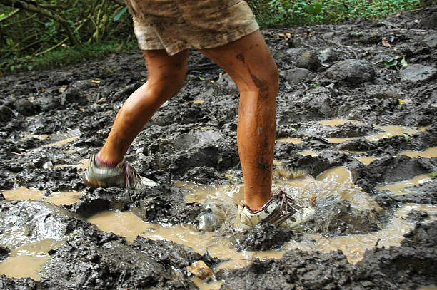 jovem chapinhar na lama - mud dirt road road dirt imagens e fotografias de stock