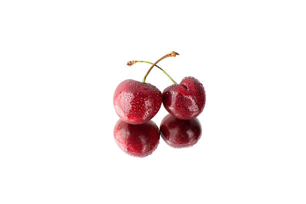 Two sweet cherries on white reflective background stock photo