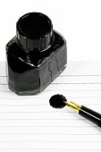 tintenfass-schwarz-und-stift-auf-papier-