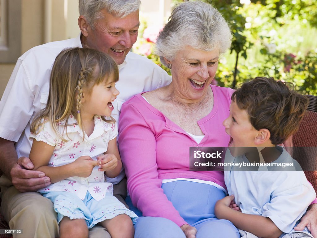 Ridere con i nipoti nonni - Foto stock royalty-free di 60-69 anni