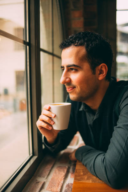 istock Young Man Looking Through a Window in a Rainy Day 920178984