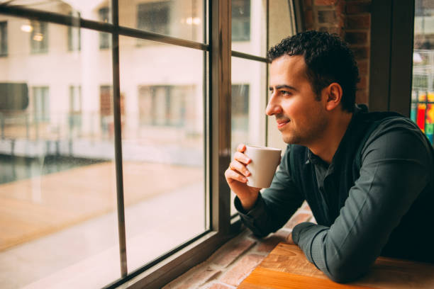 istock Young Man Looking Through a Window in a Rainy Day 920178988