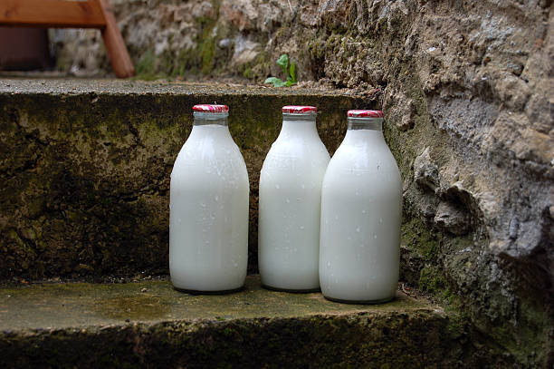 manhã leite garrafas na porta passo - milk milk bottle bottle glass imagens e fotografias de stock