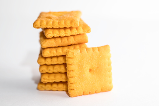 Cheese flavored small square crackers on a white background