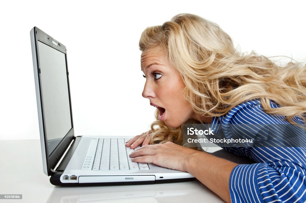 Scioccato ragazza con espressione su computer portatile - Foto stock royalty-free di Abbigliamento casual
