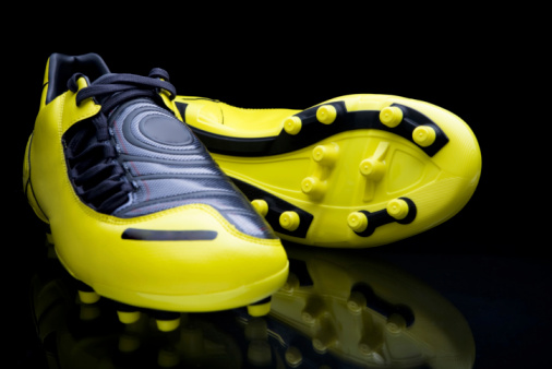 Yellow soccer footwear on black background