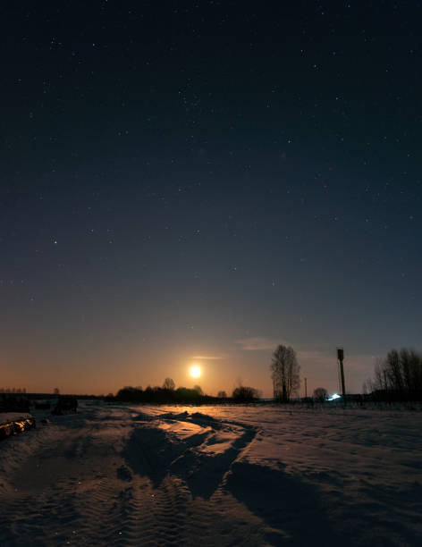 istock Moon rising over the field, winter night. 920186078