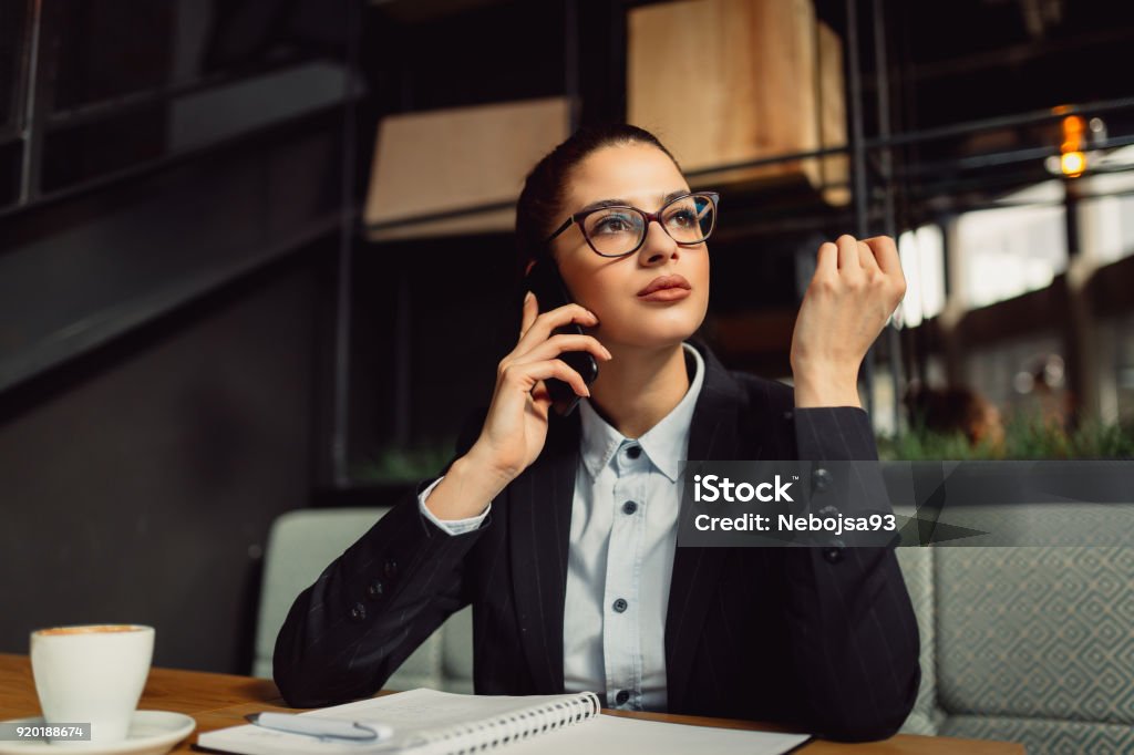 Close-up of young attractive businesswoman talking on mobile. Adult Stock Photo