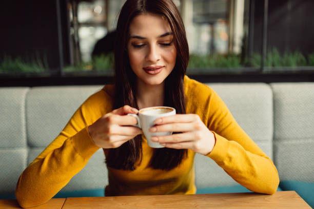 istock Close-up of a beautiful brunette while drinking coffee in cafe. 920188678