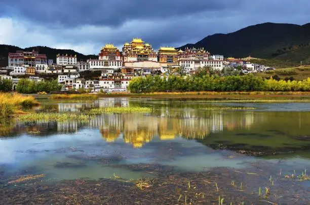 Iconic place and tourist destination Little Potala, Genden Sumtseling Monastery, Tibetan Buddhist monastery, with reflection at Zhongdian, Yunnan, China