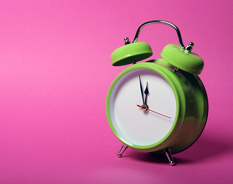 Alarm clock aginst pink background