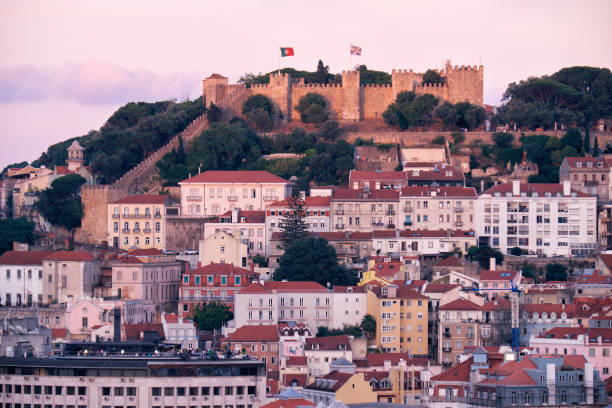Illuminated walls of Sao Jorge fort in Lisbon, Portugal at dusk.