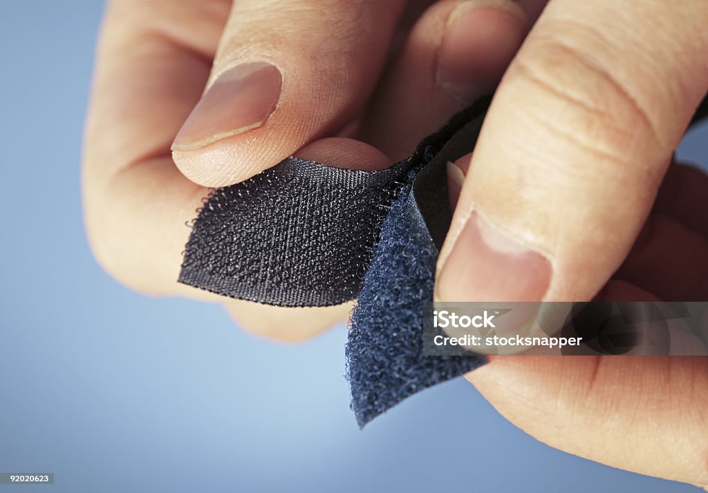 Pair of hands holding two sides of Velcro Hook-and-loop fastener aka Velcro in closeup Nylon Fastening Tape Stock Photo