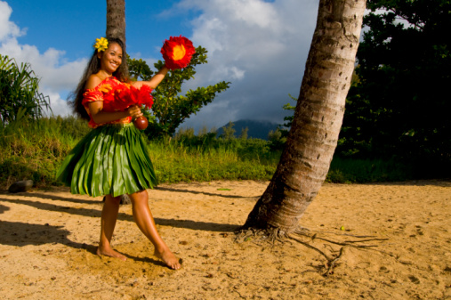 Hawaiian teenage girl dancing Hula on the beach in Kauai