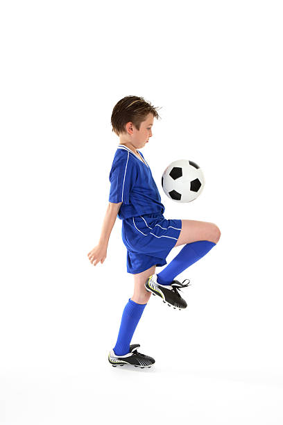 istock Boy wearing blue soccer kit and boots bouncing ball on leg 92022377