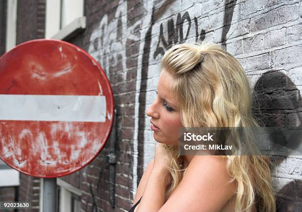 Привлекательные Блондинка Стоя Возле Красный Дорожный Знак — стоковые фотографии и другие картинки Stop - английское слово