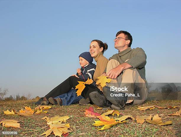 Famiglia Sedersi Con Foglie Autunnali - Fotografie stock e altre immagini di Abbigliamento casual - Abbigliamento casual, Accendere (col fuoco), Acero