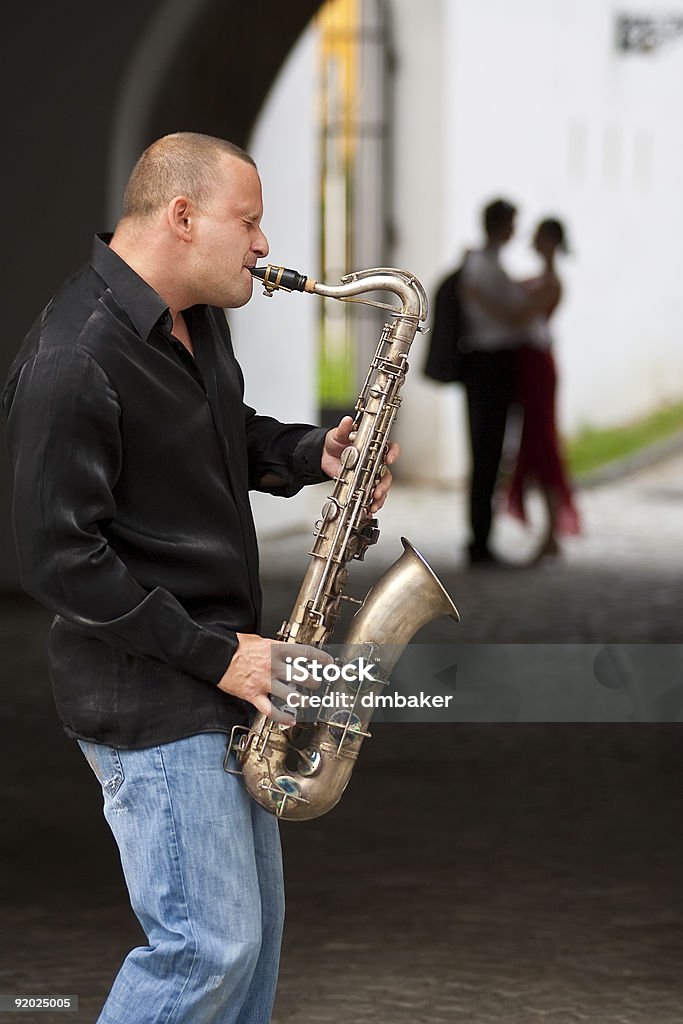 Pareja romántica en una serenata de saxofón músico de Jazz - Foto de stock de Músico ambulante libre de derechos