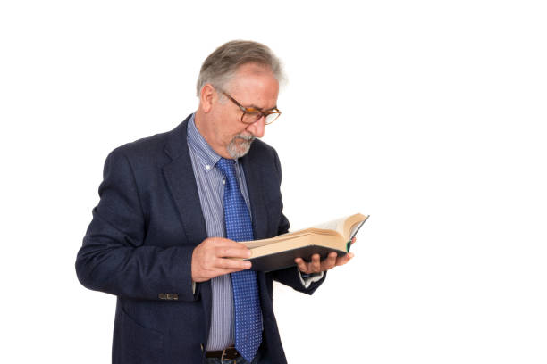 istock Senior teacher standing reading a book, isolated on white background. Education concept 920252906