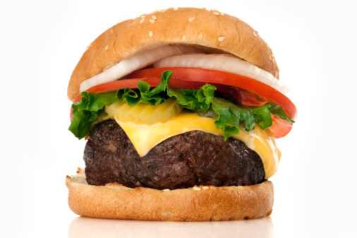 Burger with sesame bun, fresh onions, salad, prosciutto and cucumber on a white background. Horizontal orientation