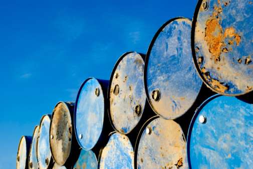 Batch of old rusty barrels against the blue sky