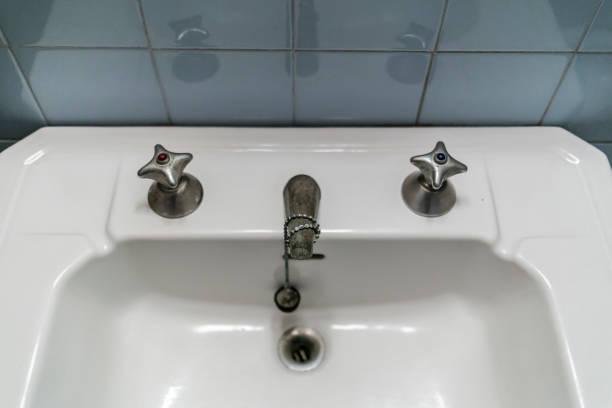 istock Old white sink with chrome faucet on a blue wall 920270938