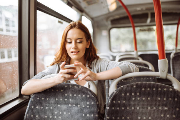 istock woman on the phone sitting on the bus 920273068