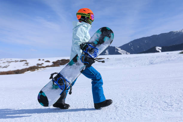 istock one snowboarder with snowboard walking in winter mountains 920284384
