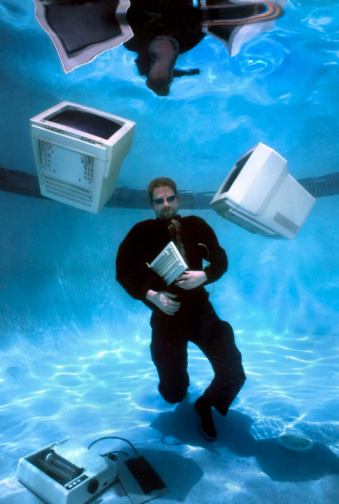 Conceptual underwater  theme of overworked, over stressed entrepreneur in over his head with work. 