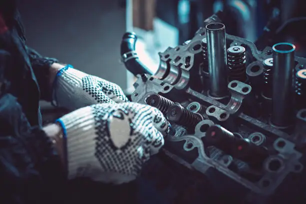 The auto mechanic deconstructs the internal combustion engine for diagnosis and repair. Closeup.