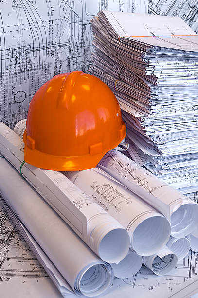istock Orange helmet and heap of project drawings 92029145