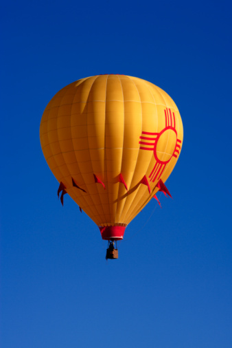 Kyiv, Ukraine - 06/26/2020: Hot air balloon in clear summer sky. Colorful balloon on blue background. Bright geometric design. Summer adventure and leisure. Aviation sport concept. Hot air balloon in flight.