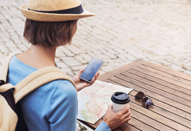 woman on vacations using phone - map cartography travel human hand imagens e fotografias de stock