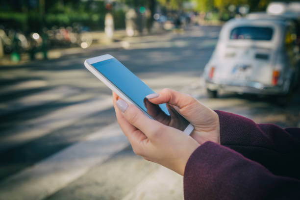 Woman using cellphone and crossing the street.