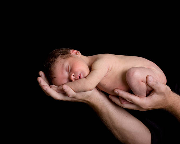istock Newborn Baby Held in Father's Hands 92031947